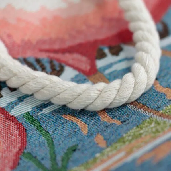 Close-up of a thick white cotton rope loop attached to multicoloured floral fabric.