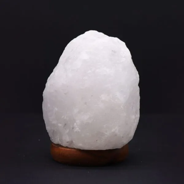 Natural white crystal rock salt lamp on a dark wooden base.