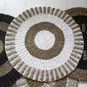 Hand-woven circular braided jute rug with a beige and white concentric pattern.