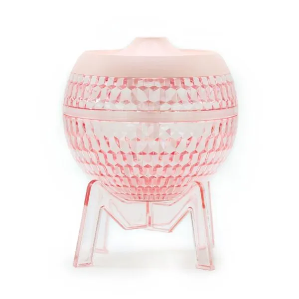 Faceted pink facial steamer and moisturiser on a clear M-shaped stand.